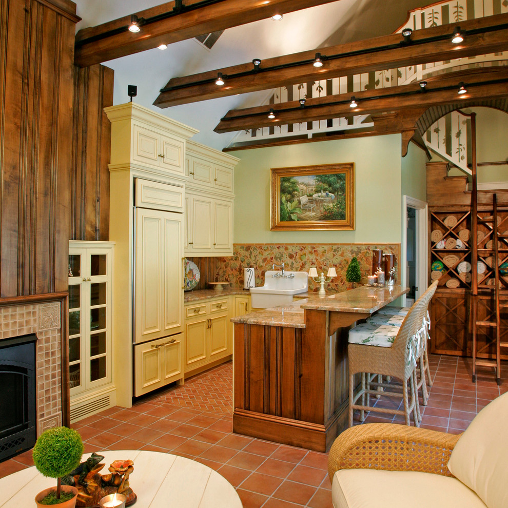 Exempel på ett lantligt kök, med en rustik diskho, luckor med infälld panel, beige skåp, granitbänkskiva, flerfärgad stänkskydd, integrerade vitvaror och klinkergolv i terrakotta