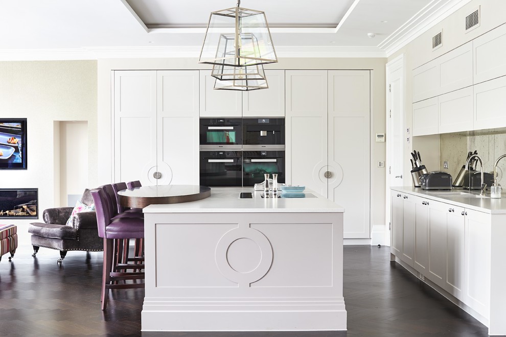 Classic l-shaped kitchen in Sussex with a submerged sink, shaker cabinets, white cabinets, dark hardwood flooring and an island.