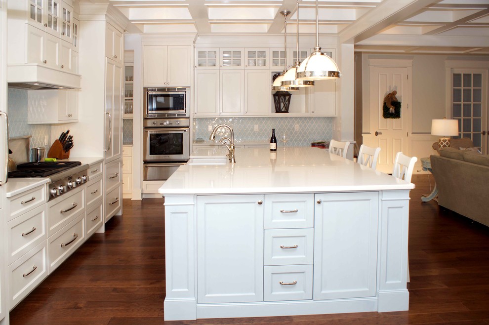 Bild på ett stort vintage kök och matrum, med en undermonterad diskho, luckor med infälld panel, vita skåp, marmorbänkskiva, blått stänkskydd, stänkskydd i keramik, rostfria vitvaror, mörkt trägolv och en köksö