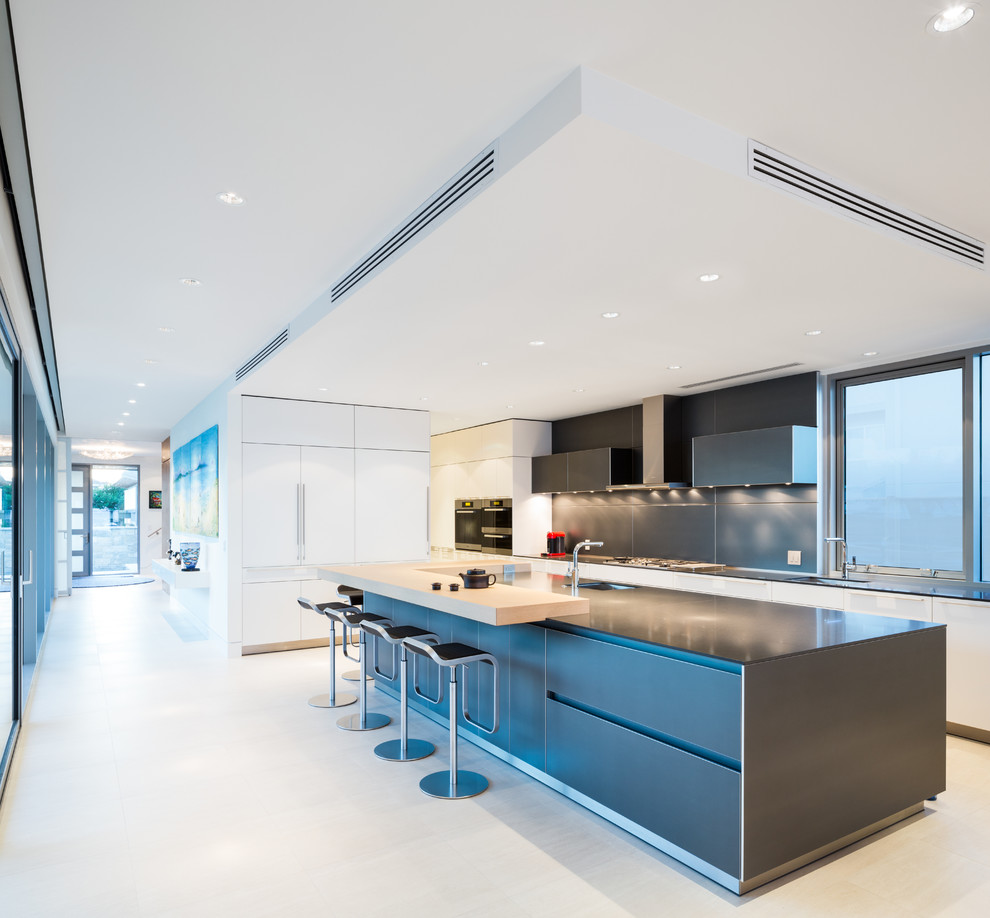 Inspiration for a large contemporary l-shaped kitchen in Vancouver with a submerged sink, flat-panel cabinets, grey cabinets, engineered stone countertops, grey splashback, integrated appliances, porcelain flooring and an island.