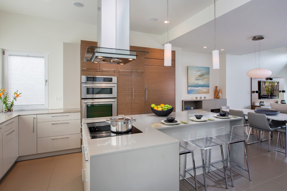 Moderne Küche mit flächenbündigen Schrankfronten, hellbraunen Holzschränken, Quarzwerkstein-Arbeitsplatte, Küchengeräten aus Edelstahl, Porzellan-Bodenfliesen und Kücheninsel in Vancouver