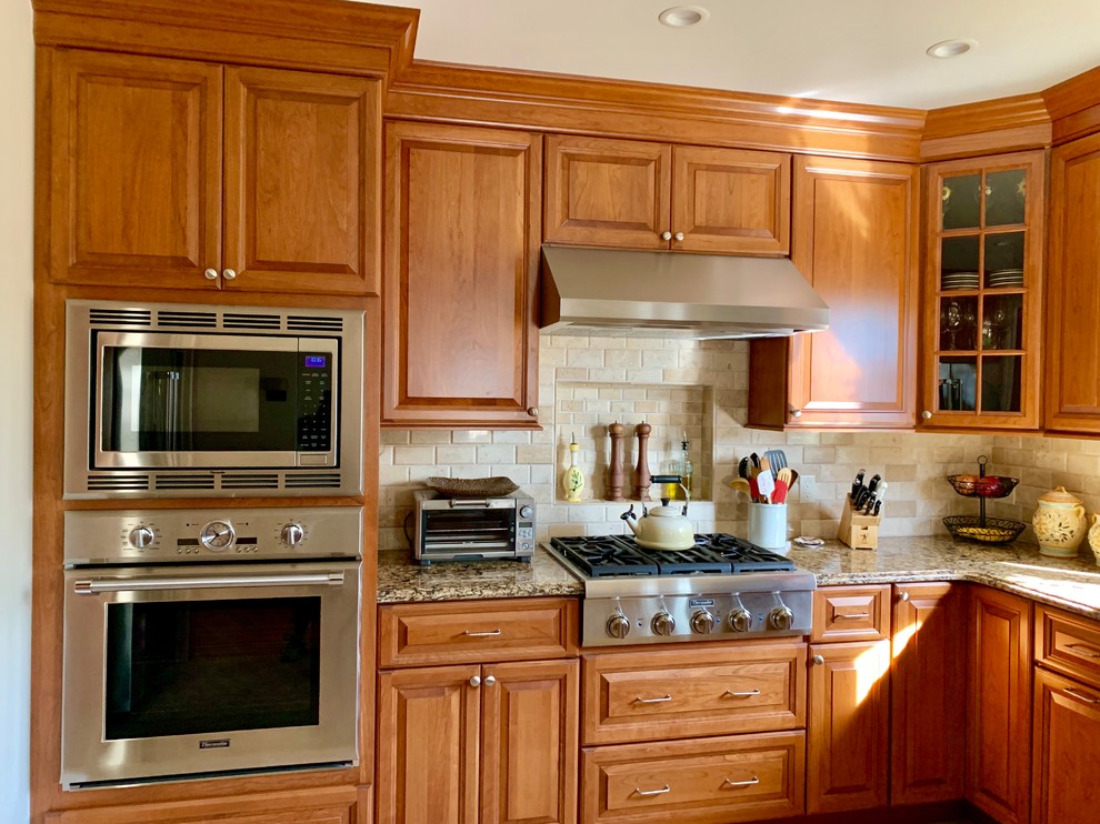 Exempel på ett mellanstort klassiskt brun brunt kök och matrum, med en nedsänkt diskho, bruna skåp, bänkskiva i kvartsit, beige stänkskydd, stänkskydd i stenkakel, rostfria vitvaror, klinkergolv i keramik och beiget golv