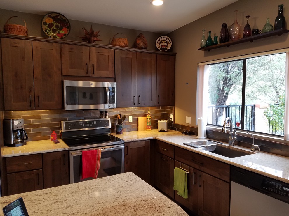 Eat-in kitchen - mid-sized southwestern l-shaped ceramic tile eat-in kitchen idea in Phoenix with an undermount sink, shaker cabinets, gray cabinets, granite countertops, brown backsplash, glass tile backsplash, stainless steel appliances and an island