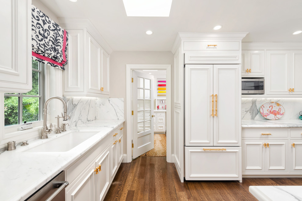 Inspiration för ett mellanstort vintage vit vitt kök, med en undermonterad diskho, luckor med infälld panel, vita skåp, marmorbänkskiva, gult stänkskydd, stänkskydd i marmor, rostfria vitvaror, mellanmörkt trägolv, en halv köksö och brunt golv