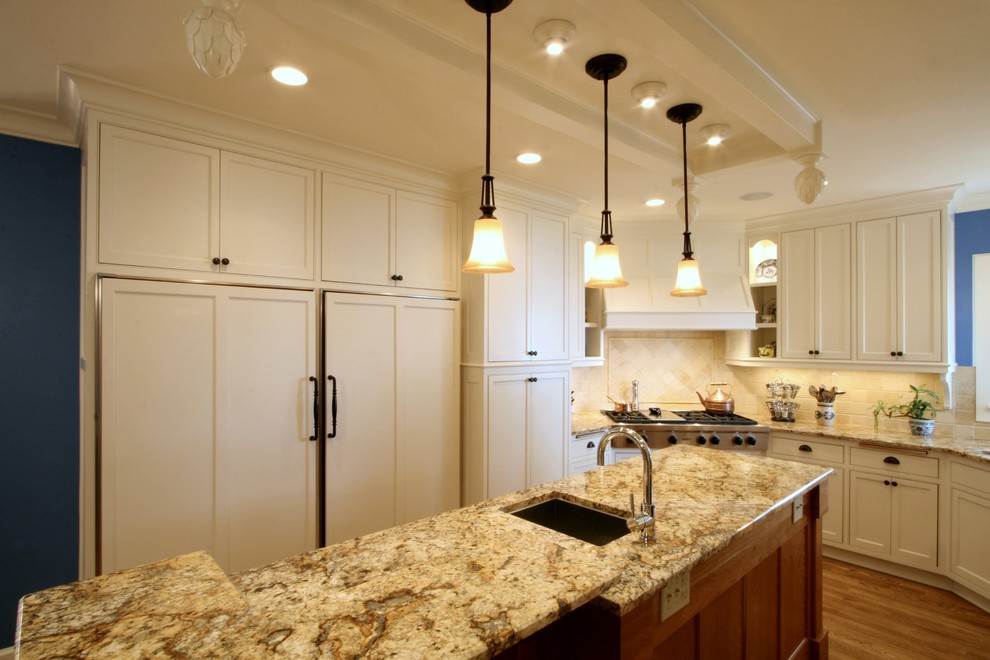 Eat-in kitchen - traditional u-shaped eat-in kitchen idea in Milwaukee with an undermount sink, beaded inset cabinets, white cabinets, granite countertops, beige backsplash, stone tile backsplash and paneled appliances