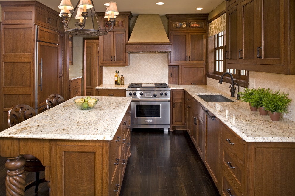 Example of a classic kitchen design in Minneapolis with recessed-panel cabinets, medium tone wood cabinets, beige backsplash and paneled appliances
