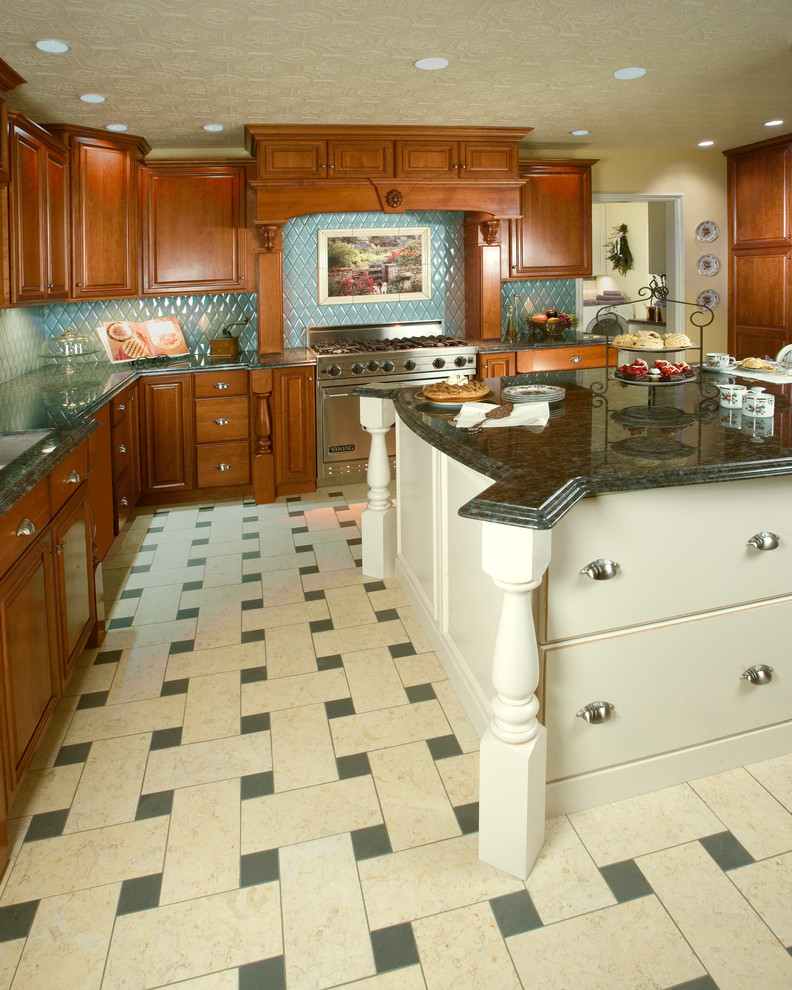 Inspiration for a large timeless u-shaped limestone floor enclosed kitchen remodel in Los Angeles with a double-bowl sink, raised-panel cabinets, medium tone wood cabinets, granite countertops, blue backsplash, ceramic backsplash, stainless steel appliances and an island