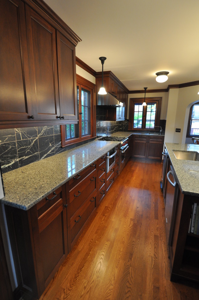 Imagen de cocina alargada y estrecha clásica con electrodomésticos de acero inoxidable y encimera de granito