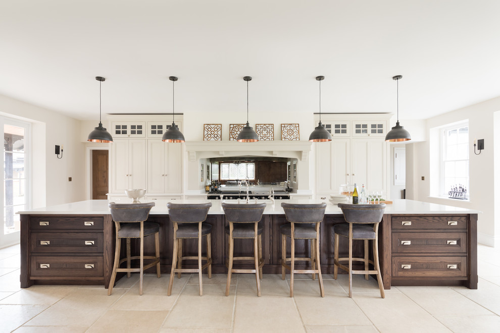 Große Klassische Küche mit beigen Schränken, Rückwand aus Spiegelfliesen, Kücheninsel, beigem Boden und weißer Arbeitsplatte in Sonstige