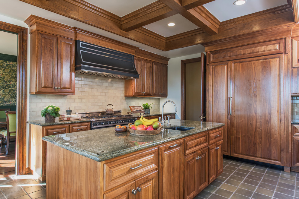 Enclosed kitchen - large traditional galley porcelain tile enclosed kitchen idea in Los Angeles with an undermount sink, raised-panel cabinets, dark wood cabinets, beige backsplash, paneled appliances, an island, granite countertops and ceramic backsplash