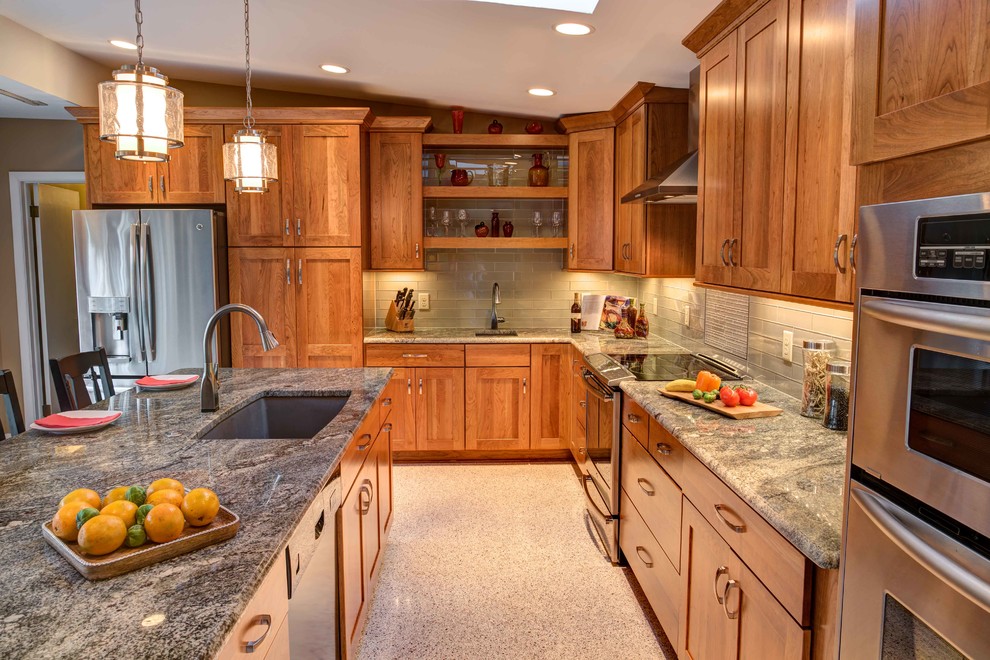 Example of a mid-sized 1960s l-shaped terrazzo floor open concept kitchen design in Raleigh with an undermount sink, shaker cabinets, medium tone wood cabinets, granite countertops, beige backsplash, glass tile backsplash, stainless steel appliances and an island