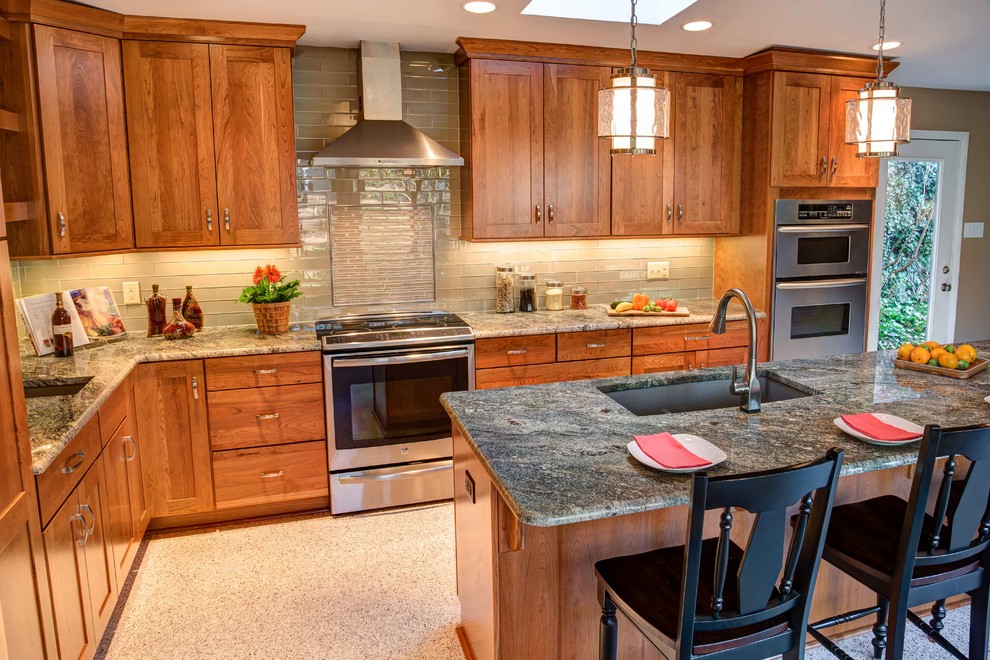 Mid-sized 1960s l-shaped terrazzo floor open concept kitchen photo in Raleigh with an undermount sink, shaker cabinets, medium tone wood cabinets, granite countertops, beige backsplash, glass tile backsplash, stainless steel appliances and an island