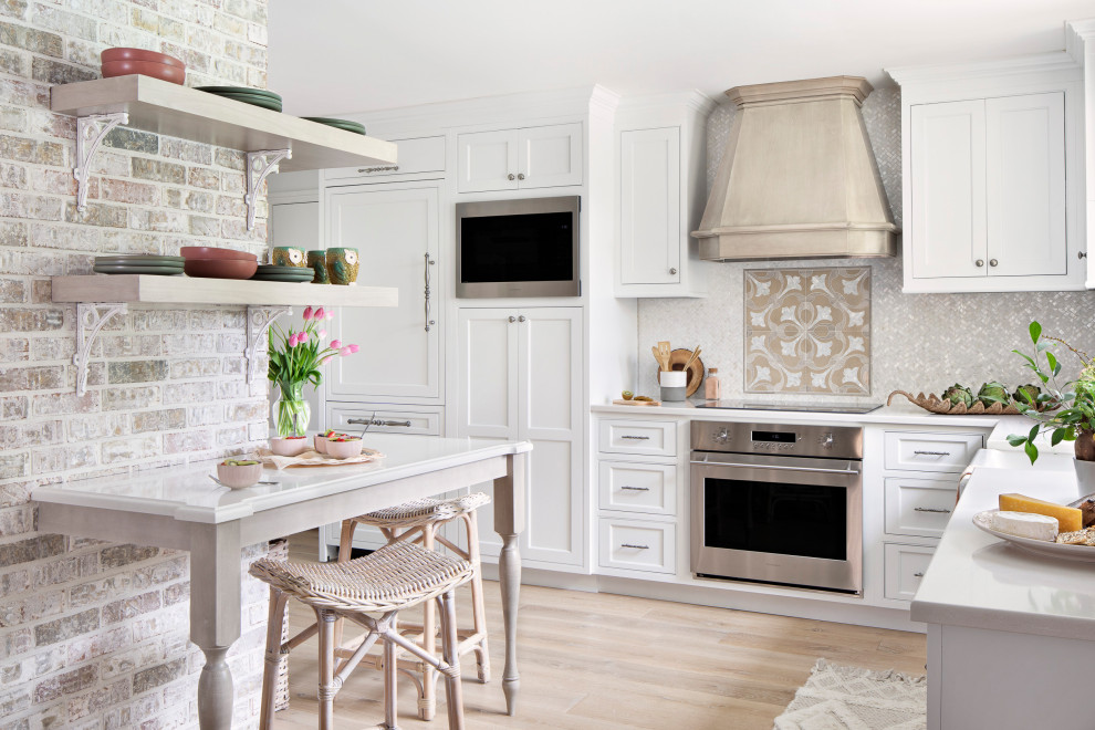 Bild på ett shabby chic-inspirerat vit vitt kök, med en rustik diskho, luckor med profilerade fronter, vita skåp, bänkskiva i kvarts, vitt stänkskydd, integrerade vitvaror, ljust trägolv och beiget golv