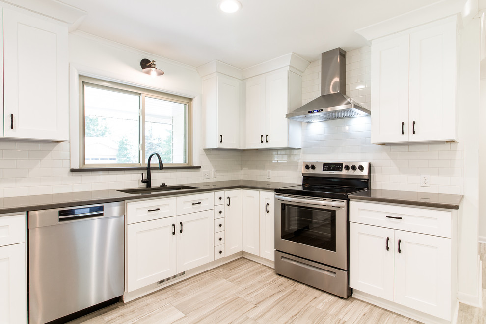 Exempel på ett mellanstort lantligt grå grått kök, med en undermonterad diskho, skåp i shakerstil, vita skåp, bänkskiva i kvarts, vitt stänkskydd, stänkskydd i tunnelbanekakel, rostfria vitvaror, klinkergolv i keramik, en halv köksö och grått golv