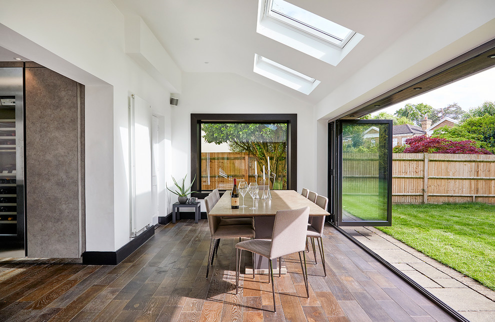 Idee per una grande sala da pranzo aperta verso il soggiorno minimal con pavimento in legno massello medio e pavimento marrone