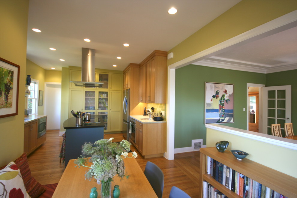 На фото: кухня с светлыми деревянными фасадами и паркетным полом среднего тона