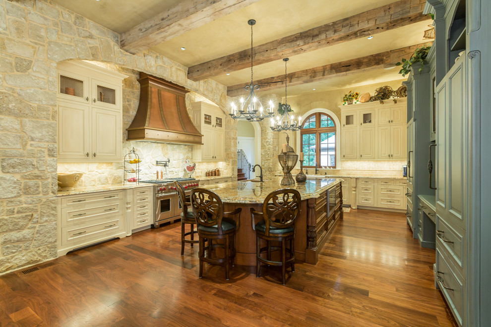 Immagine di un'ampia cucina classica con ante con bugna sagomata, top in granito, elettrodomestici in acciaio inossidabile e pavimento in legno massello medio