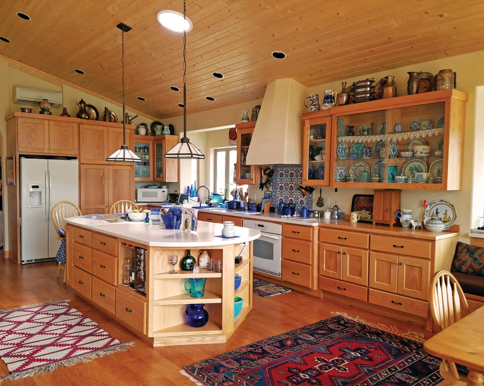 Bild på ett stort amerikanskt kök, med en dubbel diskho, skåp i shakerstil, skåp i ljust trä, bänkskiva i koppar, flerfärgad stänkskydd, stänkskydd i porslinskakel, vita vitvaror, laminatgolv och en köksö