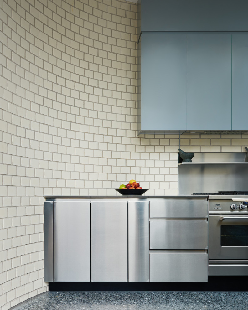 Modelo de cocina contemporánea grande con encimera de acero inoxidable, salpicadero beige, salpicadero de azulejos tipo metro, electrodomésticos de acero inoxidable y encimeras grises