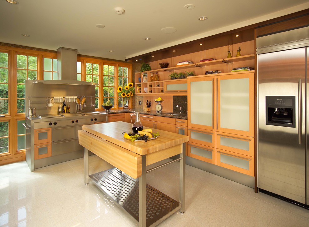 Foto på ett mellanstort eklektiskt l-kök, med rostfria vitvaror, skåp i ljust trä och en köksö