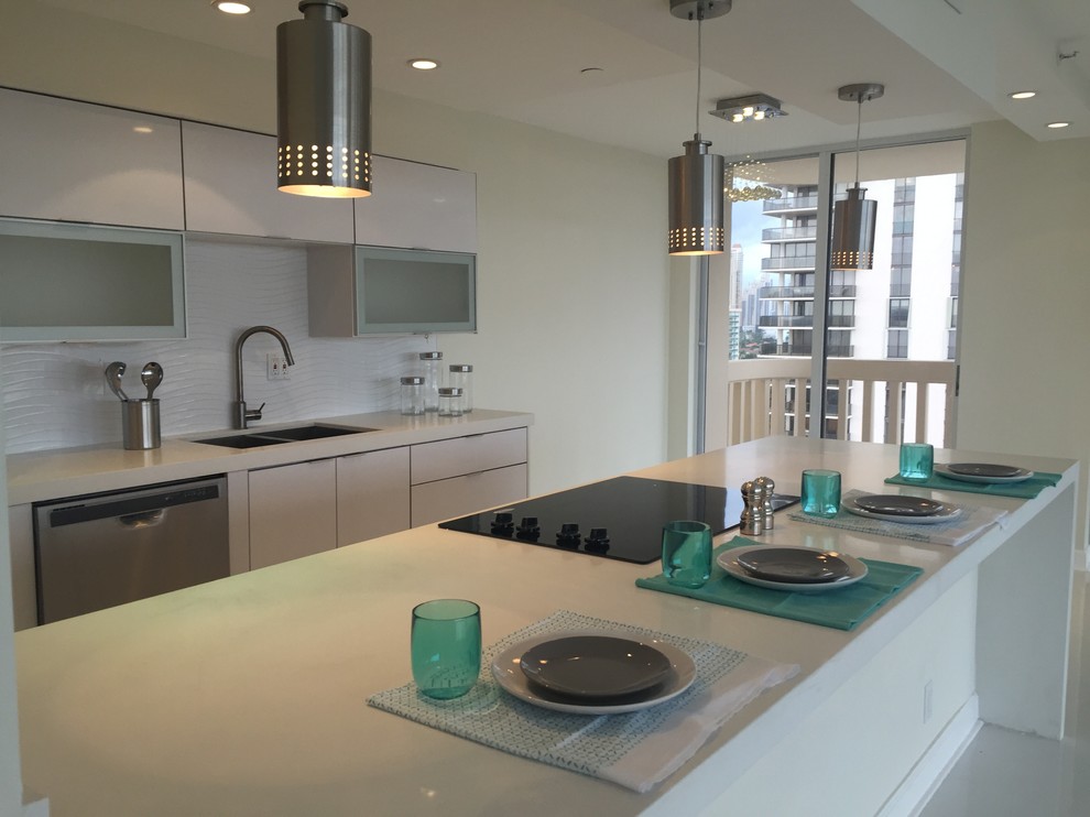 Photo of a medium sized contemporary single-wall kitchen/diner in Miami with a submerged sink, glass-front cabinets, white cabinets, quartz worktops, white splashback, porcelain splashback, stainless steel appliances, porcelain flooring and a breakfast bar.