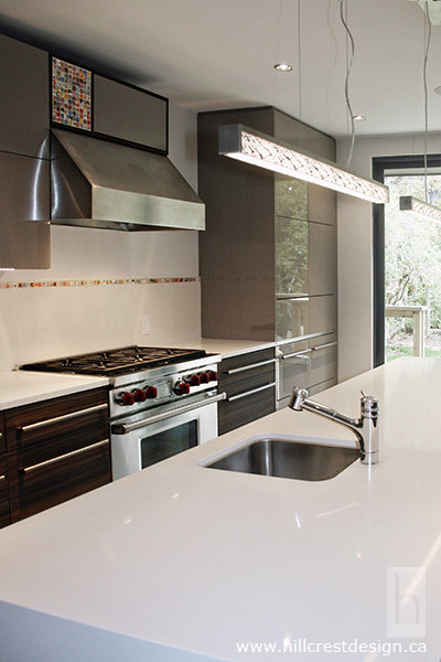 Example of a huge minimalist l-shaped porcelain tile open concept kitchen design in Toronto with an undermount sink, flat-panel cabinets, quartz countertops, white backsplash, ceramic backsplash, stainless steel appliances and an island