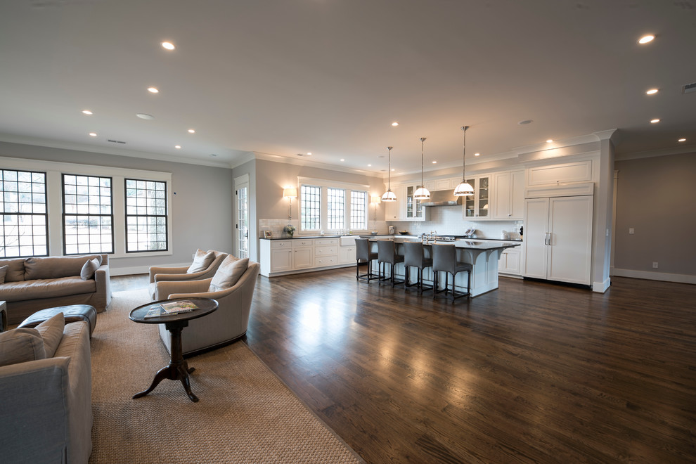 Example of a large classic l-shaped medium tone wood floor open concept kitchen design in Birmingham with a farmhouse sink, limestone countertops, white backsplash, subway tile backsplash, stainless steel appliances and an island