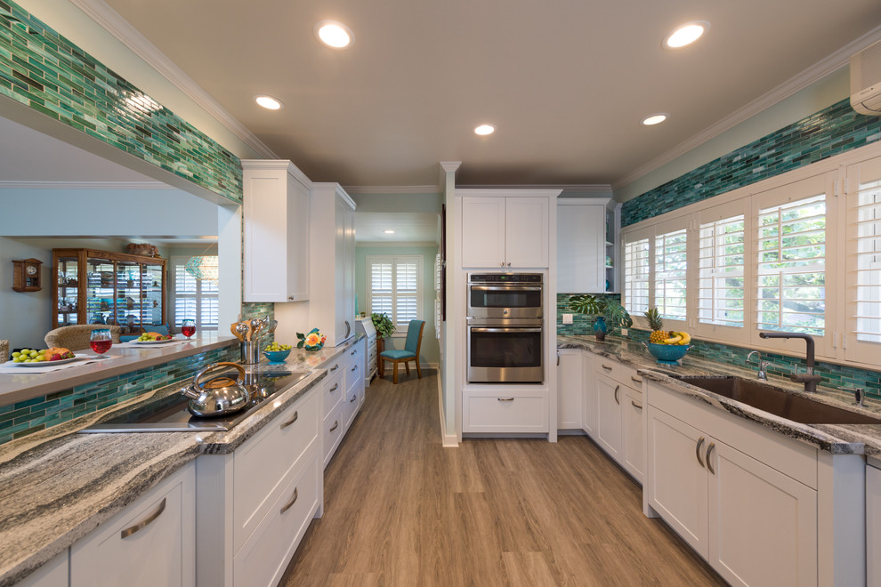 Mid-sized island style vinyl floor and gray floor enclosed kitchen photo in Hawaii with an undermount sink, shaker cabinets, white cabinets, quartzite countertops, blue backsplash, glass tile backsplash, paneled appliances and no island