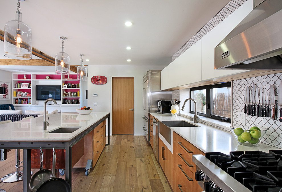 На фото: кухня в современном стиле с техникой из нержавеющей стали, с полувстраиваемой мойкой (с передним бортиком) и обоями на стенах