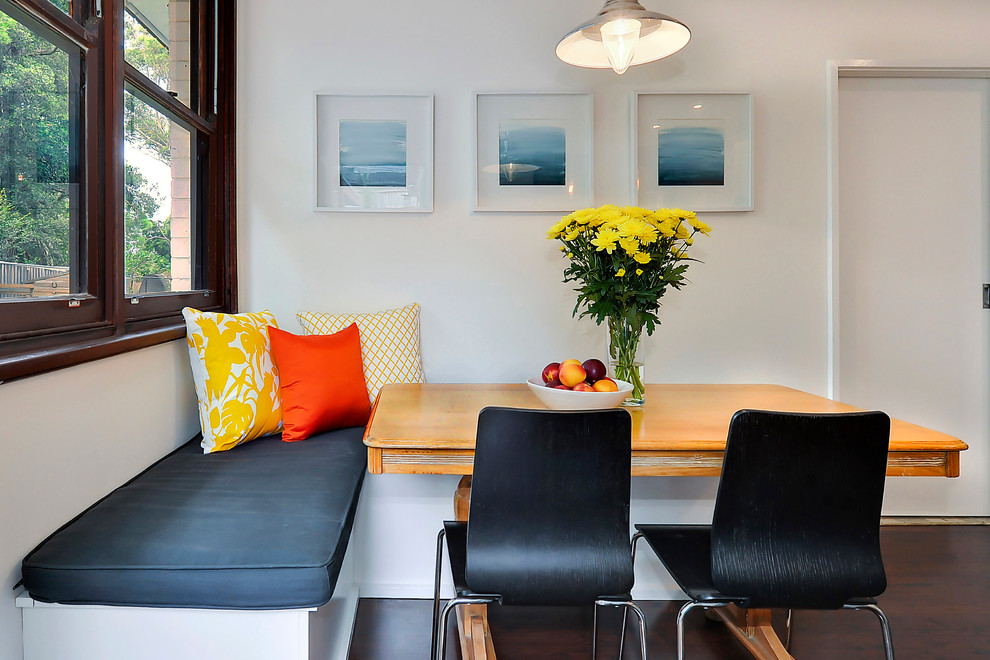 Immagine di una sala da pranzo aperta verso la cucina minimalista di medie dimensioni con pareti bianche, parquet scuro e pavimento marrone