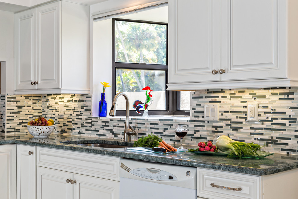 Mid-sized transitional galley eat-in kitchen photo in Miami with raised-panel cabinets, white cabinets, granite countertops, multicolored backsplash, an undermount sink, matchstick tile backsplash and white appliances