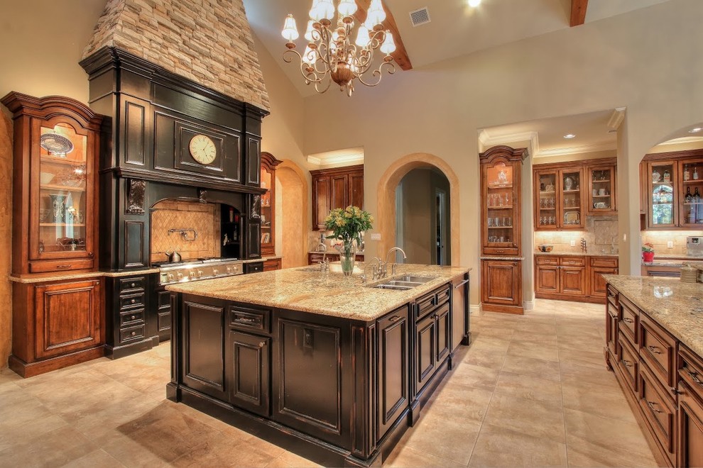 Kitchen - large craftsman l-shaped beige floor kitchen idea in Austin with a triple-bowl sink, shaker cabinets, medium tone wood cabinets, granite countertops, beige backsplash, stainless steel appliances and two islands