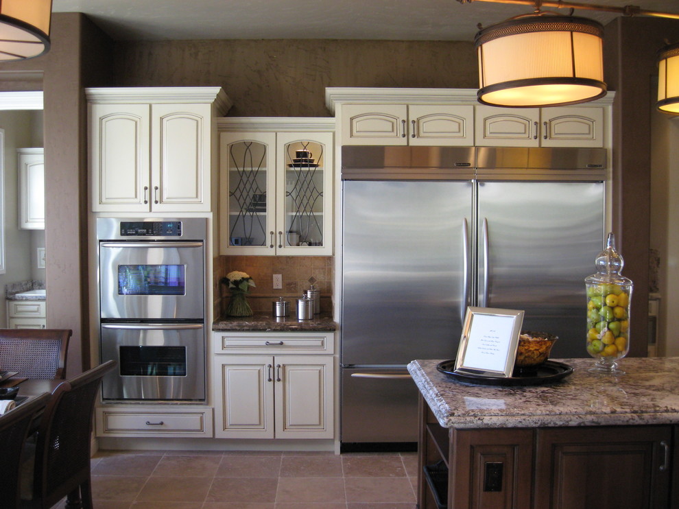 Modelo de cocina tradicional grande con armarios con paneles con relieve, puertas de armario blancas, encimera de granito y una isla