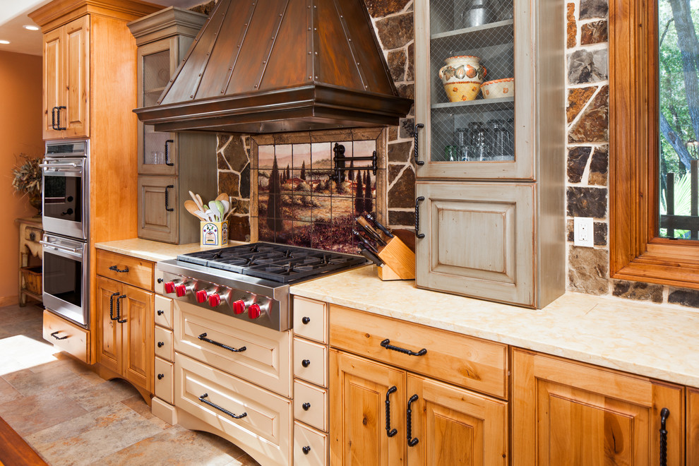 Example of a large farmhouse u-shaped ceramic tile open concept kitchen design in Other with a farmhouse sink, raised-panel cabinets, medium tone wood cabinets, limestone countertops, brown backsplash, stone tile backsplash, paneled appliances and an island