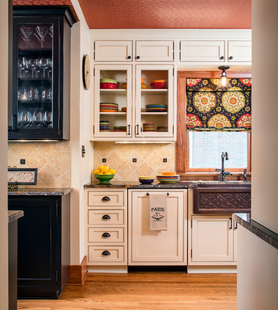 Bild på ett mellanstort lantligt kök, med en rustik diskho, luckor med profilerade fronter, granitbänkskiva, beige stänkskydd, integrerade vitvaror, mellanmörkt trägolv, en köksö, beige skåp och stänkskydd i keramik