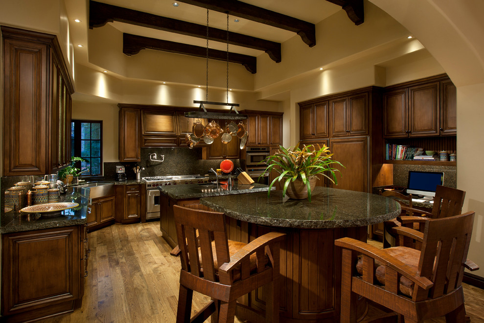 Exempel på ett stort medelhavsstil kök, med en rustik diskho, luckor med upphöjd panel, skåp i mörkt trä, granitbänkskiva, flerfärgad stänkskydd, stänkskydd i sten, rostfria vitvaror, mellanmörkt trägolv och en köksö