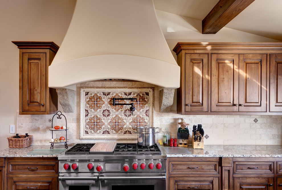 Example of a large tuscan u-shaped ceramic tile eat-in kitchen design in Santa Barbara with a double-bowl sink, beaded inset cabinets, medium tone wood cabinets, granite countertops, beige backsplash, paneled appliances and an island