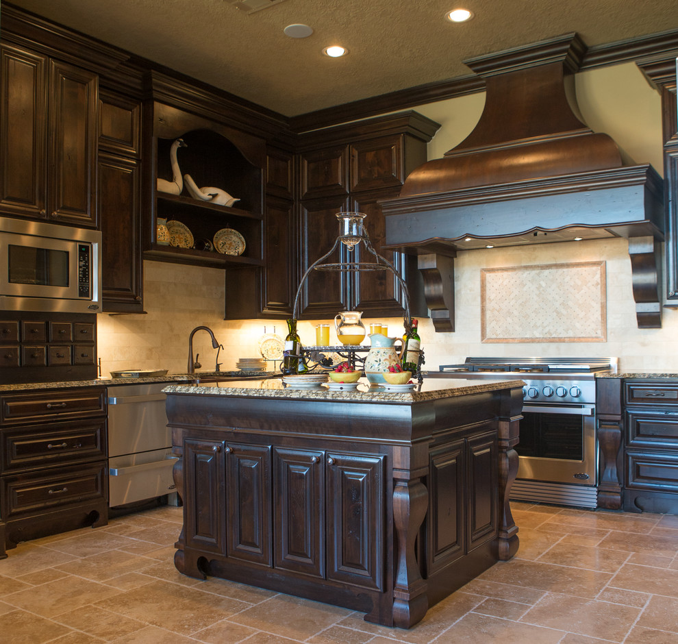 Foto på ett mellanstort amerikanskt kök, med en undermonterad diskho, luckor med upphöjd panel, skåp i mörkt trä, granitbänkskiva, beige stänkskydd, stänkskydd i keramik, rostfria vitvaror, travertin golv, en köksö och beiget golv