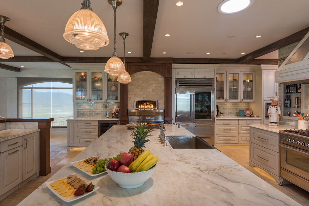Example of a large tuscan beige floor kitchen pantry design in Hawaii with a farmhouse sink, raised-panel cabinets, white cabinets, green backsplash, ceramic backsplash, stainless steel appliances and two islands