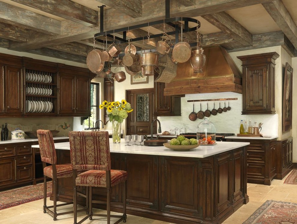 This is an example of a mediterranean kitchen in St Louis with raised-panel cabinets and dark wood cabinets.