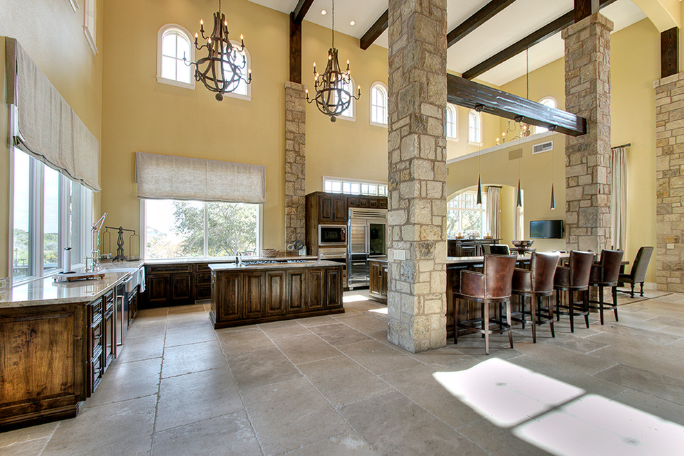 Foto på ett stort medelhavsstil kök, med en undermonterad diskho, luckor med upphöjd panel, skåp i mellenmörkt trä, granitbänkskiva, beige stänkskydd, rostfria vitvaror, kalkstensgolv och flera köksöar