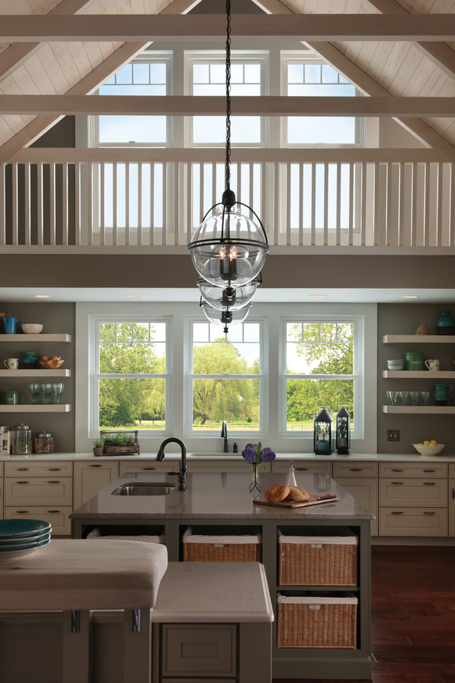 Foto på ett mellanstort lantligt linjärt kök och matrum, med en undermonterad diskho, luckor med infälld panel, vita skåp, bänkskiva i kvarts, mörkt trägolv, en köksö och brunt golv