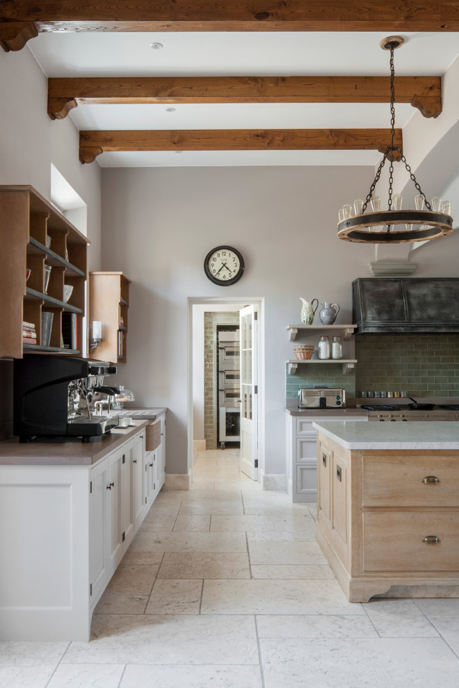 This is an example of a large country u-shaped eat-in kitchen in London with light wood cabinets, marble benchtops, green splashback, subway tile splashback, stainless steel appliances, limestone floors and multiple islands.