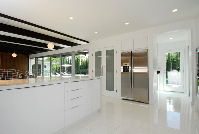 Design ideas for a large contemporary l-shaped open plan kitchen in Orange County with a double-bowl sink, flat-panel cabinets, white cabinets, composite countertops, multi-coloured splashback, stone slab splashback, stainless steel appliances, lino flooring and an island.
