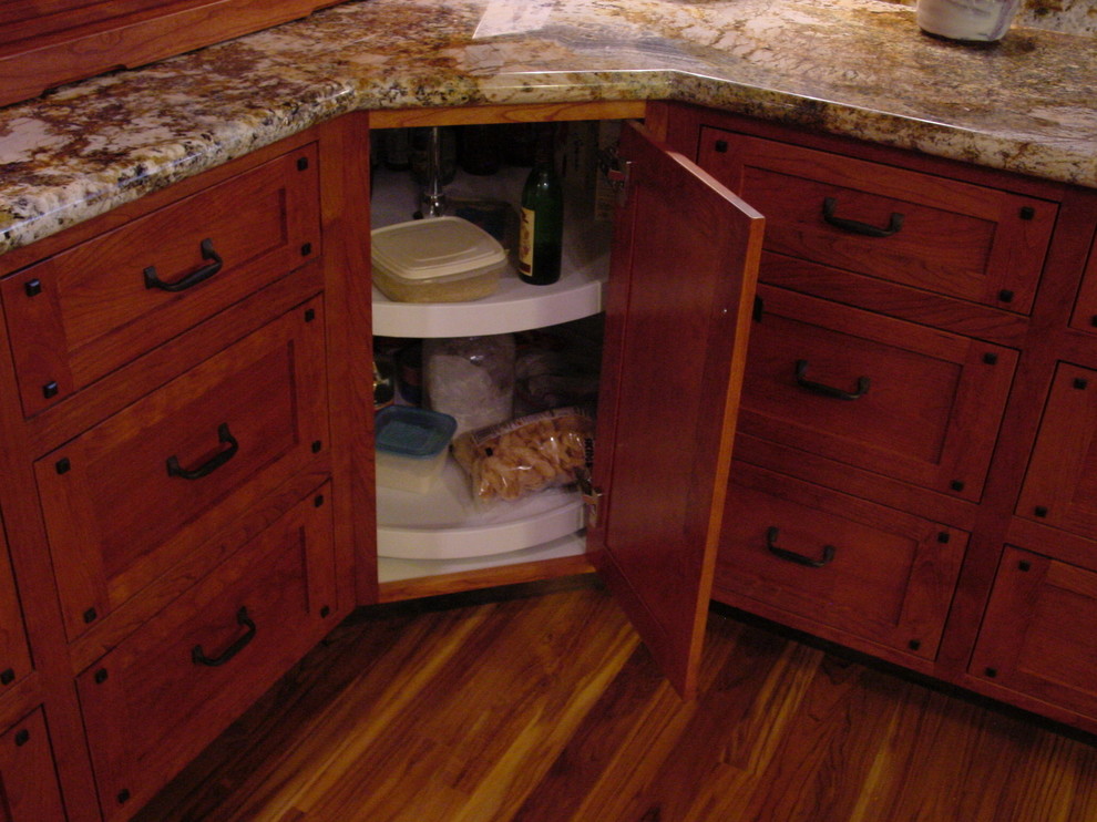 Bild på ett mycket stort amerikanskt kök, med en undermonterad diskho, skåp i shakerstil, skåp i mellenmörkt trä, granitbänkskiva, rostfria vitvaror, mellanmörkt trägolv och en köksö