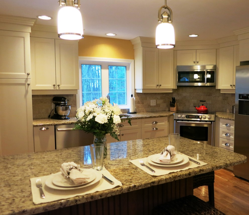 Exempel på ett mellanstort klassiskt kök, med en undermonterad diskho, luckor med infälld panel, vita skåp, granitbänkskiva, beige stänkskydd, stänkskydd i stenkakel, rostfria vitvaror, mellanmörkt trägolv, en köksö och brunt golv