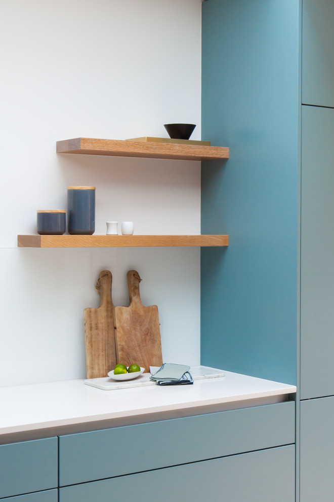 Mittelgroße Moderne Küche mit flächenbündigen Schrankfronten und Kücheninsel in London