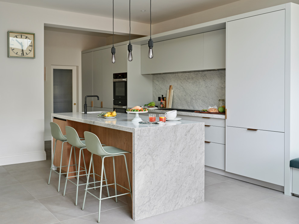 Foto på ett mellanstort 60 tals grå linjärt kök och matrum, med en undermonterad diskho, släta luckor, grå skåp, marmorbänkskiva, grått stänkskydd, stänkskydd i marmor, svarta vitvaror, en köksö och grått golv
