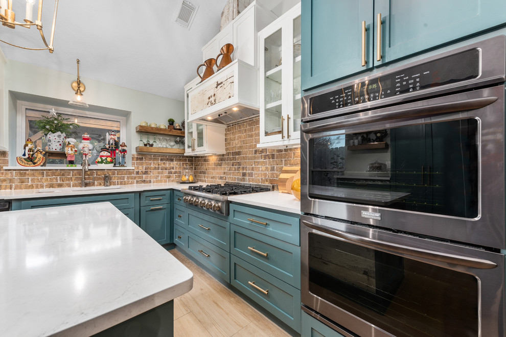 Eat-in kitchen - mid-sized cottage u-shaped light wood floor and beige floor eat-in kitchen idea in Houston with an undermount sink, shaker cabinets, turquoise cabinets, quartz countertops, brown backsplash, brick backsplash, stainless steel appliances, an island and white countertops