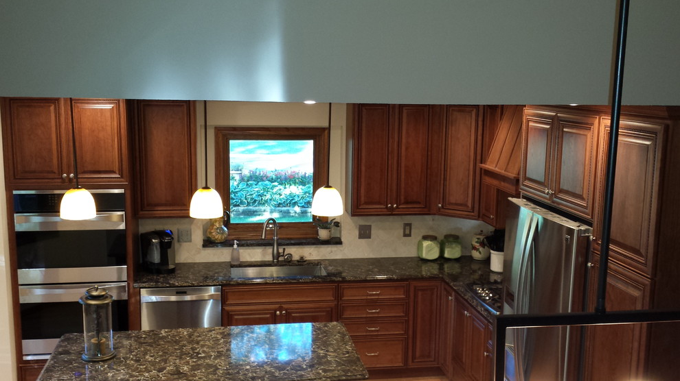 Immagine di una cucina classica con lavello sottopiano, ante lisce, ante in legno scuro, top in laminato, paraspruzzi multicolore e elettrodomestici in acciaio inossidabile